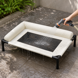 Cream elevated dog cot being rinsed clean